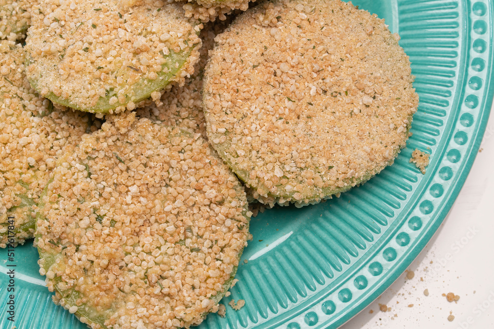 Green tomato slices breaded and ready to go into the frying pan Green tomato slices breaded and ready to go into the frying pan