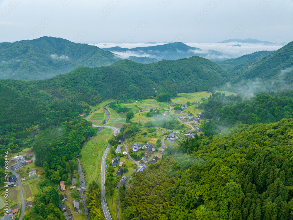 Early morning fog clears over small farms in rural mountain village Early morning fog clears over small farms in rural mountain village