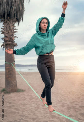 Canvas Print young latin woman walking and balancing on the webbing, slack lining yoga at the