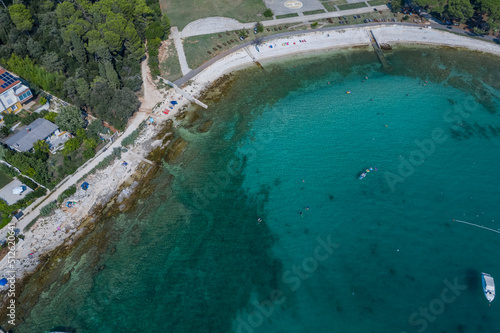 Aerial top view of a beach with turquoise blue green sea water of the adriatic sea, Rovinj, Croatia 