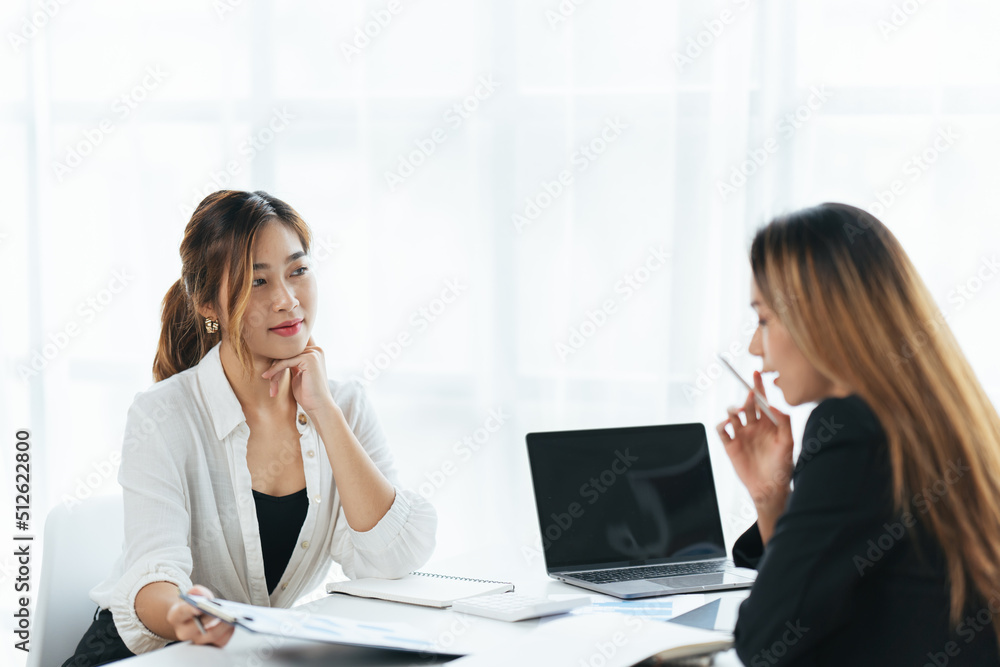 Two business woman check report before presentation to customer, Business women at office desk working together on a laptop, teamwork concept. Two business woman check report before presentation to customer, Business women at office desk working together on a laptop, teamwork concept.
