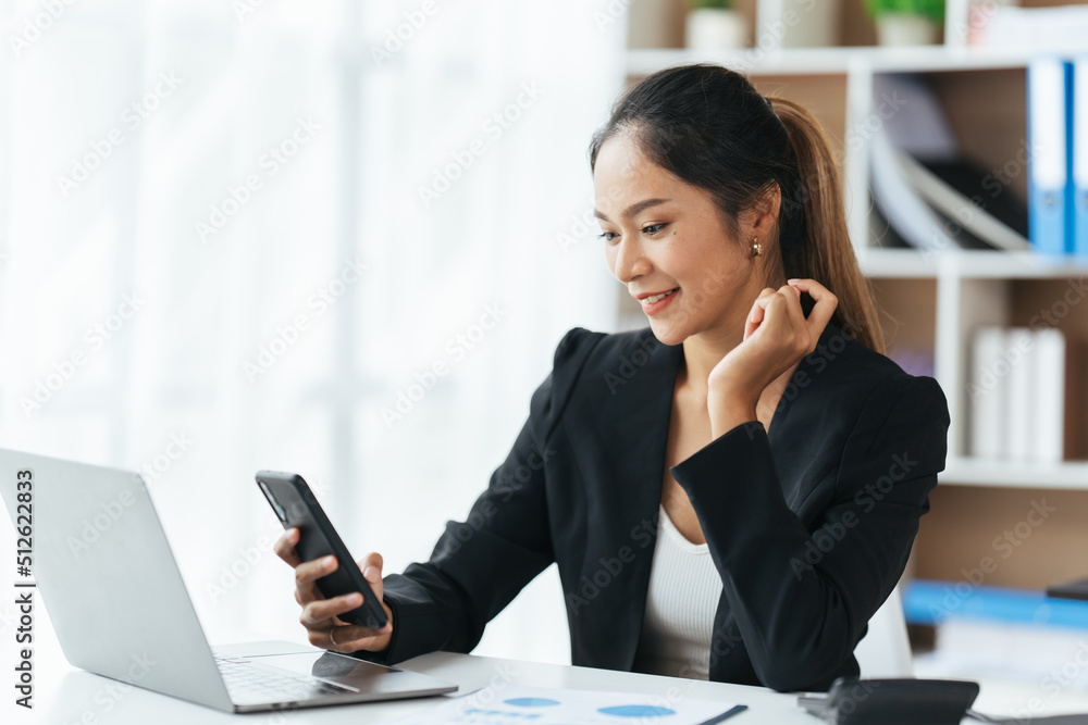 Portrait of happy lady typing in mobile while locating at desk in office, Young business woman on the phone at office. Portrait of happy lady typing in mobile while locating at desk in office, Young business woman on the phone at office.