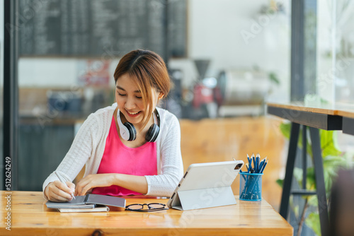 Photography Portrait of smiling beautiful Asian business woman enjoy the idea sitting at office, Asian student girl look at laptop while doing homework making video call abroad using internet friend connection