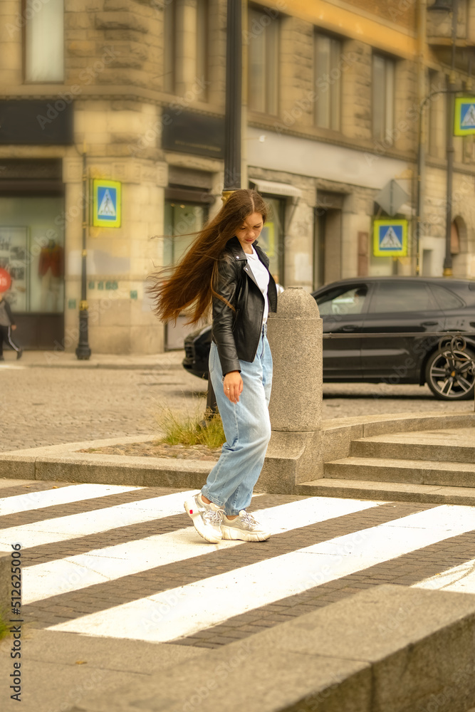 Woman with long hair walking along the street of the city