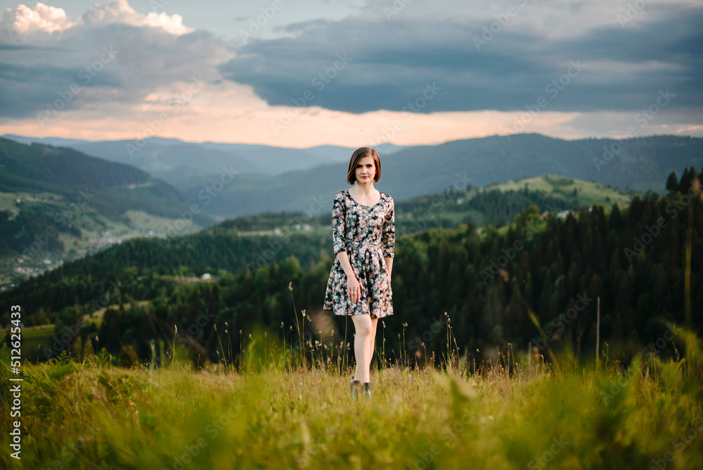 A romantic walk of a young woman in a short dress along fields and mountains. The concept of female freedom, emancipation and love