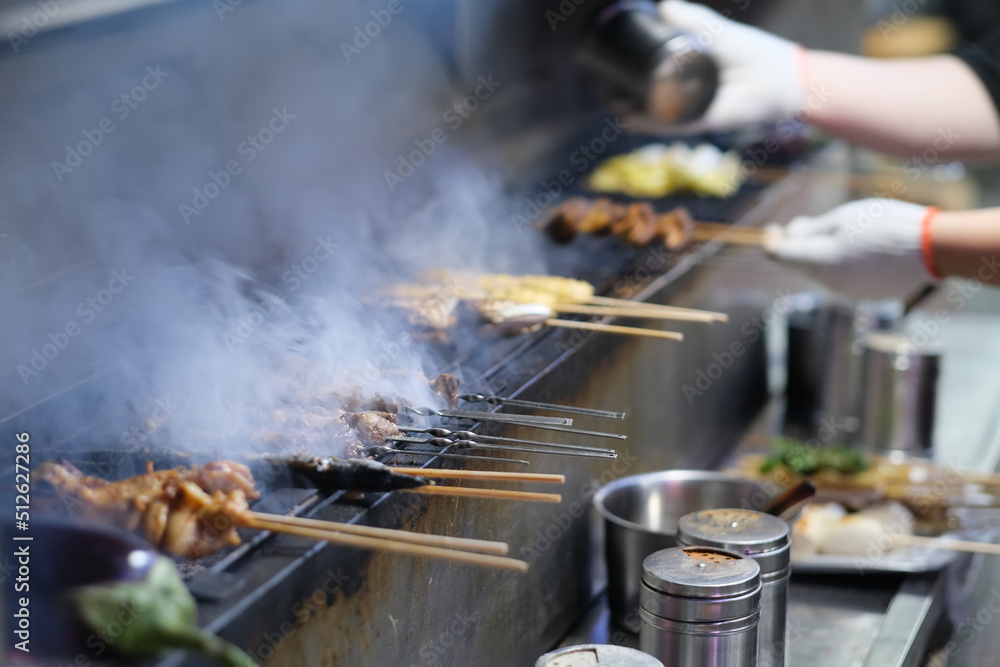 cooking barbecue kebabs on grill. Street food in China cooking barbecue kebabs on grill. Street food in China