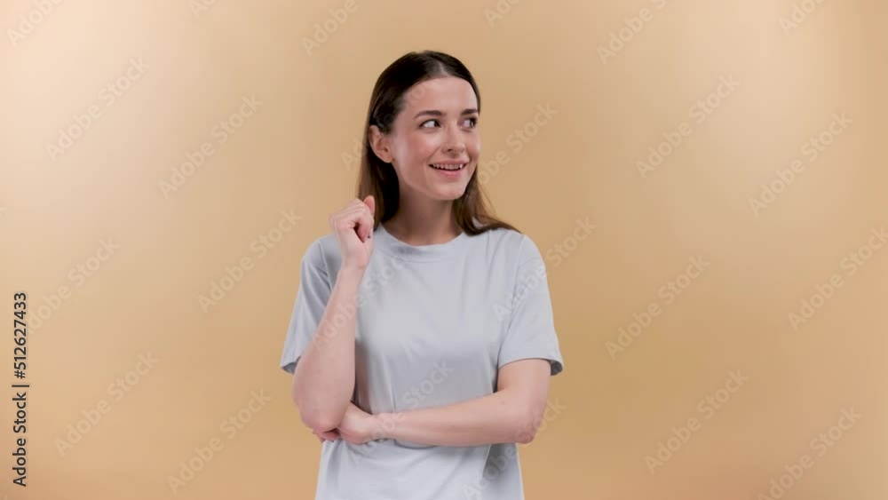 Young woman isolated over beige background in white t-shirt got an idea, holding finger proudly up in the air after realizing a great idea, saying eureka Young woman isolated over beige background in white t-shirt got an idea, holding finger proudly up in the air after realizing a great idea, saying eureka