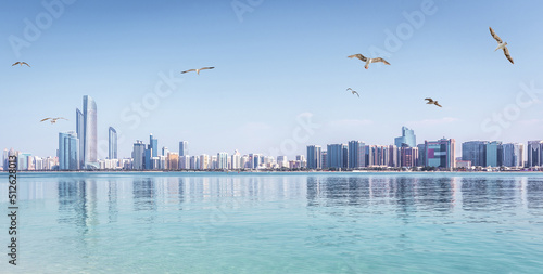 Panoramic view of Abu Dhabi Skyline UAE with skyscrapers and sea with seagulls