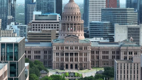 Rising aerial of Texas state capitol and flag. Austin skyline highrise skyscrapers panorama cityscape. photo