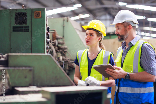 Training trainee concept. Hispanic latin male engineer explain the procedure for using the correct metal robot machine at lathe industrial factory.