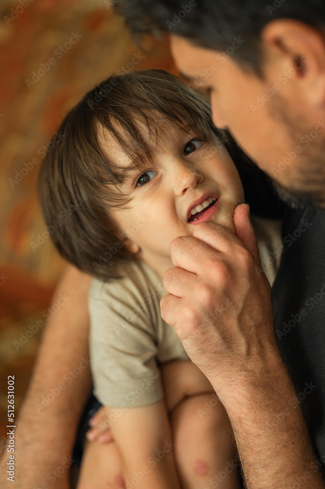 the faces of the father and son are close-up, the father spends time with his son, he talks to him, they laugh and smile, the concept of a happy family the faces of the father and son are close-up, the father spends time with his son, he talks to him, they laugh and smile, the concept of a happy family
