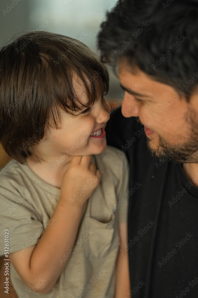 the faces of the father and son are close-up, the father spends time with his son, he talks to him, they laugh and smile, the concept of a happy family the faces of the father and son are close-up, the father spends time with his son, he talks to him, they laugh and smile, the concept of a happy family