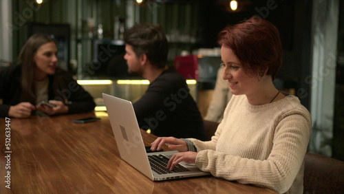 One happy millennial woman using laptop computer at cafe smiling browsing receiving positive notification