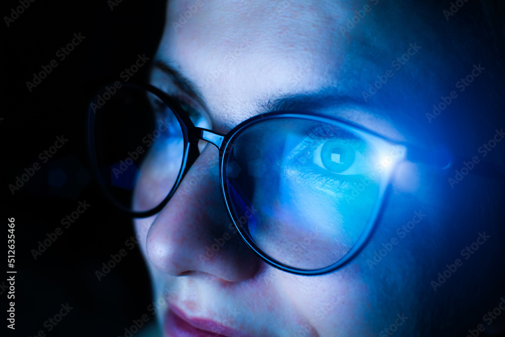 Girl works on internet. Reflection at the glasses from laptop..Close up of woman's eyes with black female glasses for working at a computer. Eye protection from blue light and rays. Girl works on internet. Reflection at the glasses from laptop..Close up of woman's eyes with black female glasses for working at a computer. Eye protection from blue light and rays.