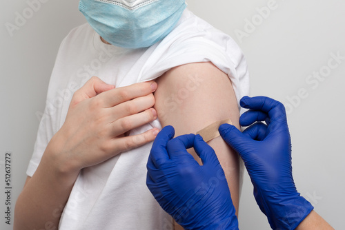 Hands of nurse glue adhesive plaster on the boy's forearm after injection