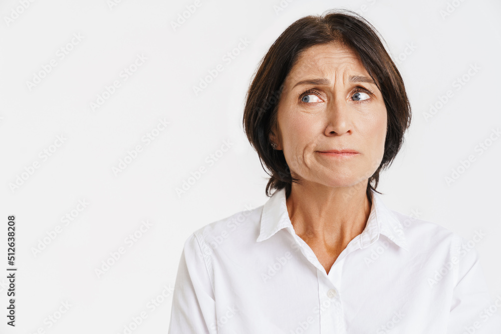 Mature brunette woman frowning and looking aside Mature brunette woman frowning and looking aside