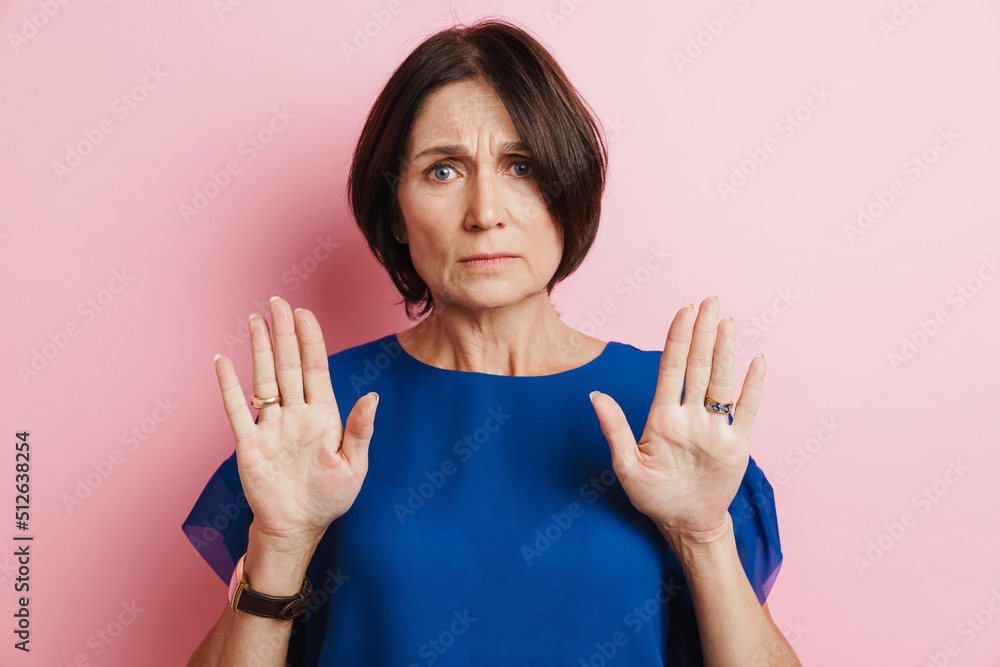 Mature brunette woman frowning while making stop gesture Mature brunette woman frowning while making stop gesture