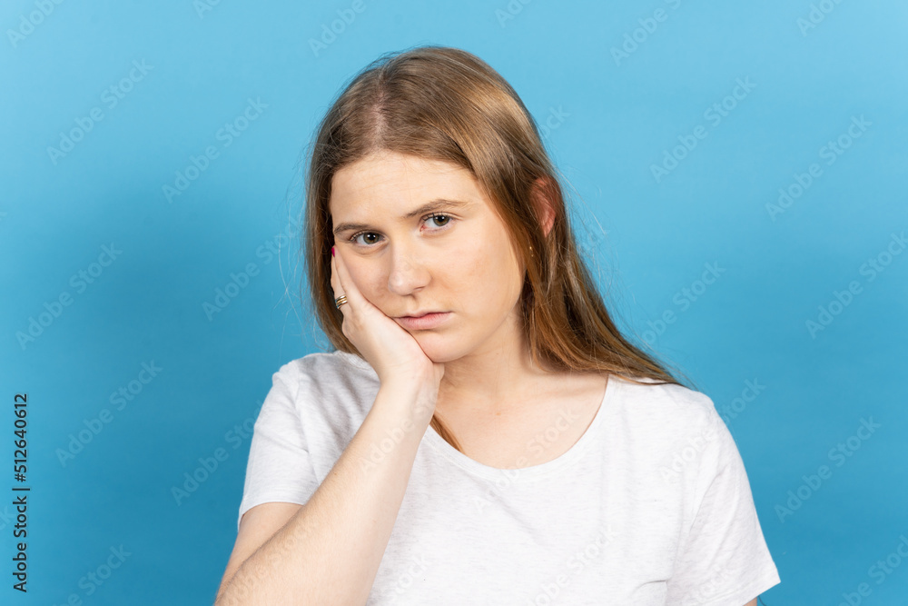 Portrait of sad young blonde woman suffering toothache isolated on blue background. Portrait of sad young blonde woman suffering toothache isolated on blue background.