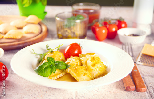 Homemade traditional italian ravioli pasta with basil and tomato cherry vegetables on the wooden table