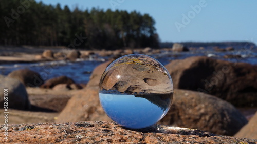 Coast of the Gulf of Finland. Crystal ball in the foreground and the beach, rocks, sea and pine forest on the horizon. Leningrad region, Russia. © Alexey_Ivanov