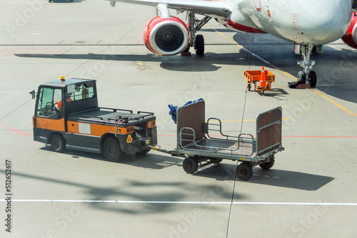 Special car and empty baggage cart next to the plane.