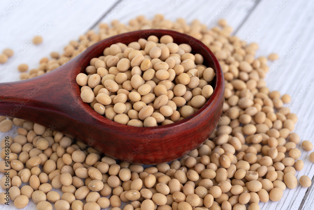 Soybeans on a wood scope white table background Soybeans on a wood scope white table background