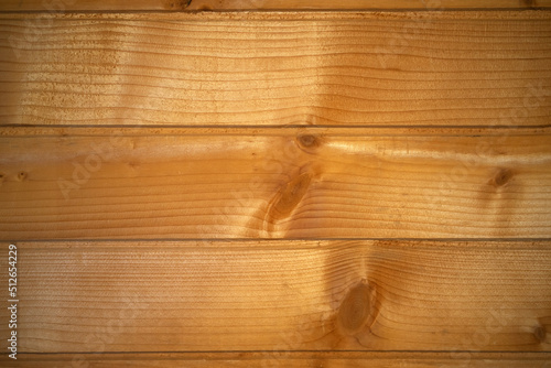 Photo of the texture of a wooden wall made of clapboard. Cladding of the building with natural wood. Light wooden background made of horizontal wooden panels.