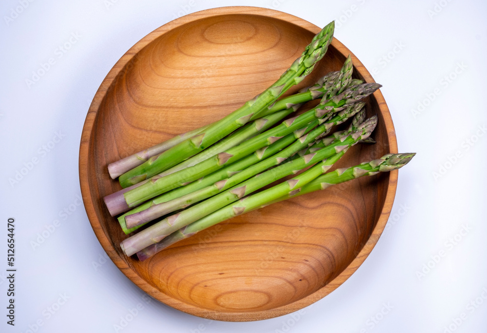  green fresh asparagus on wooden background plate , healthy food concept