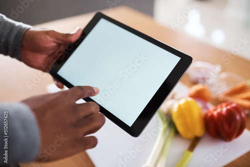 This blog always inspires me to try new recipes. Shot of an unrecognizable man using a digital tablet while cooking at home.