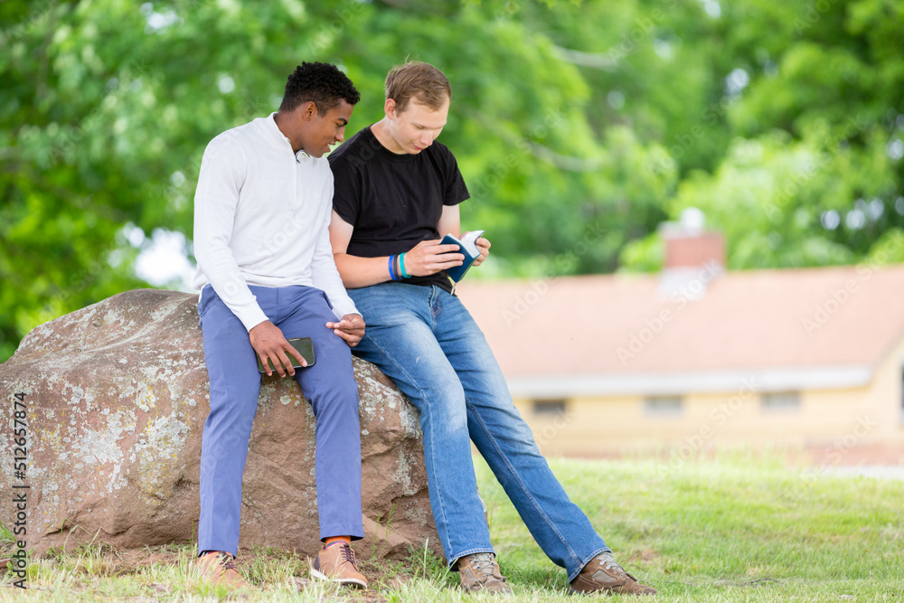 Two guys reading the Bible in the park Two guys reading the Bible in the park