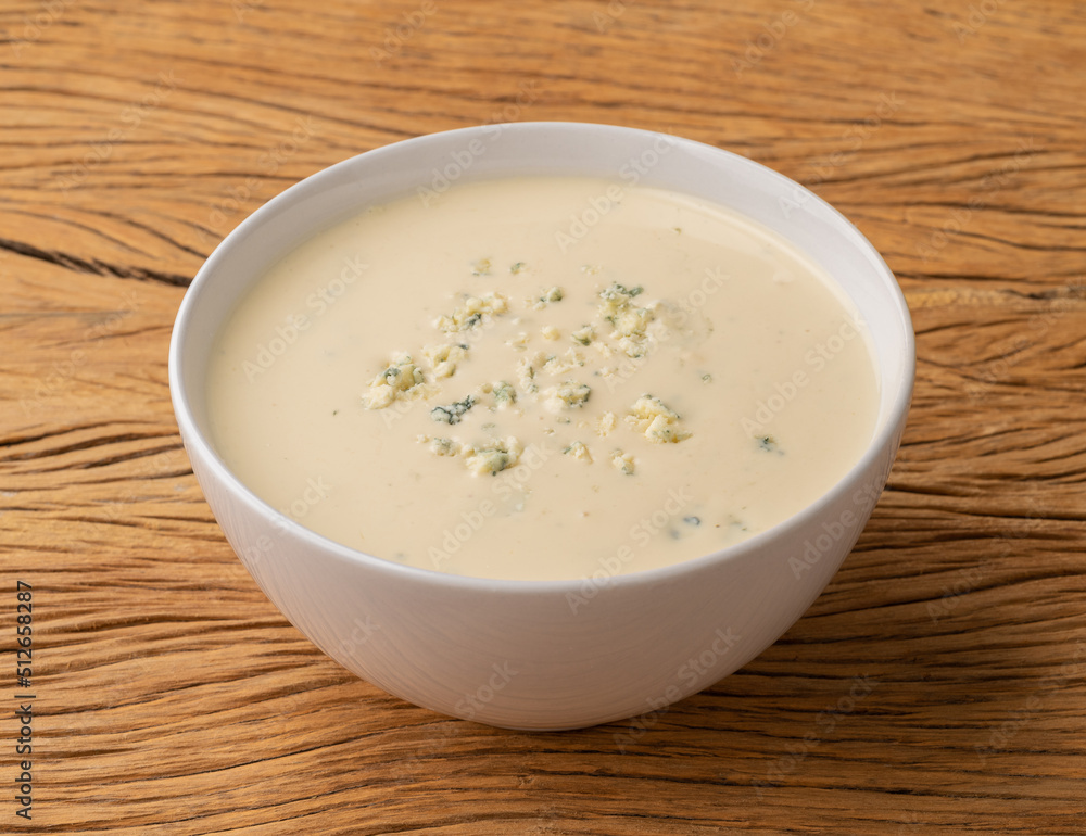 Cheese soup in a bowl over wooden table Cheese soup in a bowl over wooden table