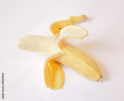 a peeled banana lies on a white background