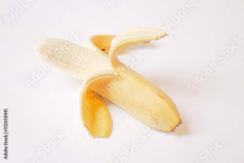 a peeled banana lies on a white background