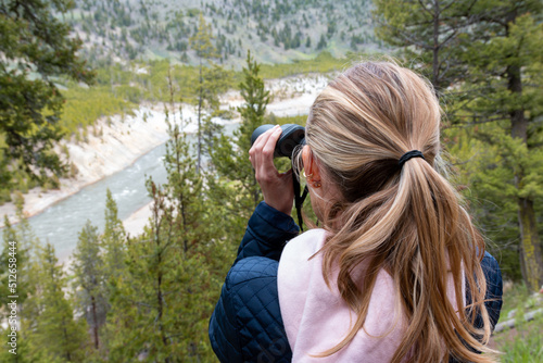Woman looking through binoculars in Yellowstone national park