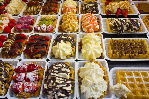Traditional tasty sweet fragrant Belgian Waffles decorated by strawberries, kiwi, banana and cream in Brussels	
