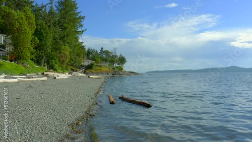 Wallpaper Mural Establishing aerial shot of ocean beach with rocks and pebbles in slow motion at summer day in Vancouver, Canada, North America. Day time on September 2021. Drone forward. ProRes 422 HQ. Torontodigital.ca
