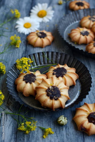 Layout of homemade cookies and flowers on a gray wooden background.