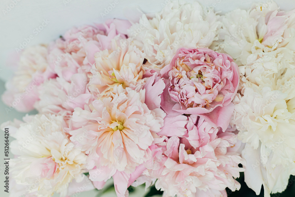 Beautiful peonies bouquet on rustic background. Stylish floral greeting card with space for text. Gentle pastel pink peony flowers composition, moody image Beautiful peonies bouquet on rustic background. Stylish floral greeting card with space for text. Gentle pastel pink peony flowers composition, moody image