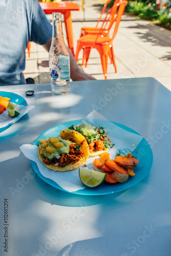 Eating tacos at outdoor table at taqueria restaurant on sunny day photo