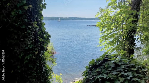 Moehnesee umrahmt von grünen Blättern. Cinemagraph mit Bewegung nur im mittleren Bereich. Ein Segelboot schwimmt nach rechts. photo