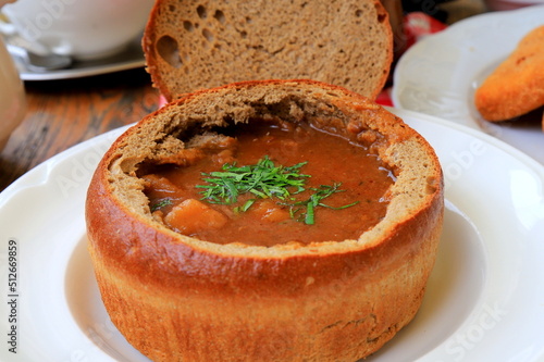 Photography Original dish - goulash soup in bread pot, plate in restaurant, cafe