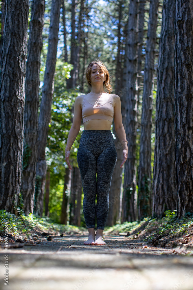 young woman performing yoga breathing in forest young woman performing yoga breathing in forest