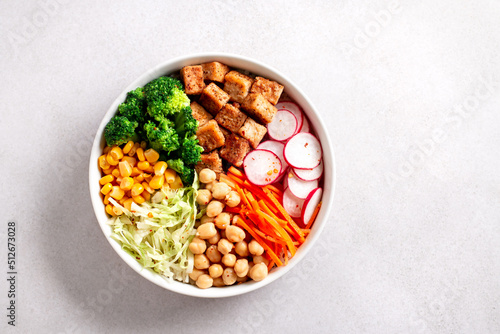 Vegan buddha bowl with tofu, colorful vegetables on base of brown rice. photo
