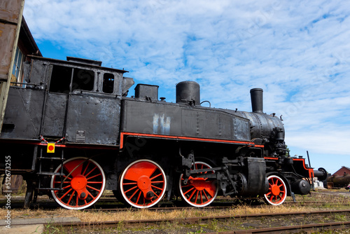 A steam locomotive standing outside of historic locomotive shed. The shot was taken in natural lighting conditions