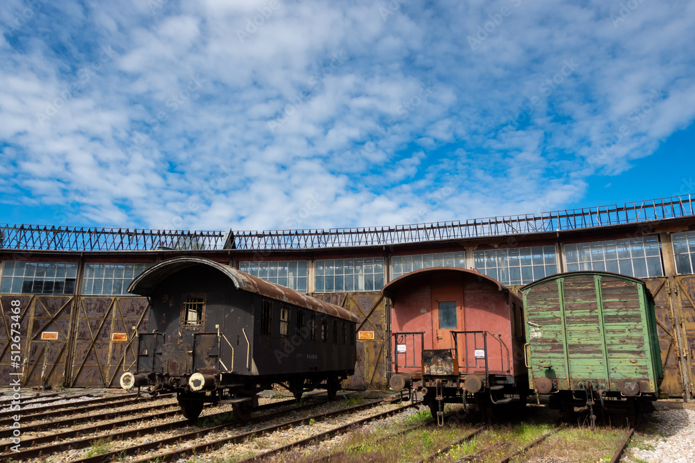 Obraz premium Old cargo cars standing outside of historic locomotive shed. The shot was taken in natural lighting conditions ....