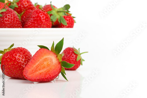 Red ripe strawberry in the white bowl  glossy background