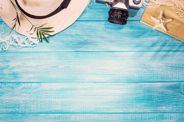 Top view of summer beach accessories on marine blue planks pier. Background with copy space and visible wood texture.