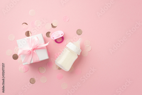Baby concept. Top view photo of white gift box with bow pacifier milk bottle and shiny confetti on isolated pastel pink background © ActionGP