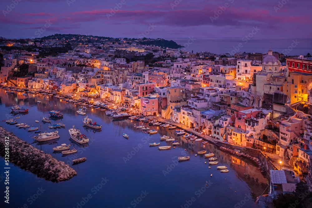 Marina Corricella at twilight, Procida, Naples, Italy. Corricella, the oldest fishing village in Procida, is built on a natural amphitheater.