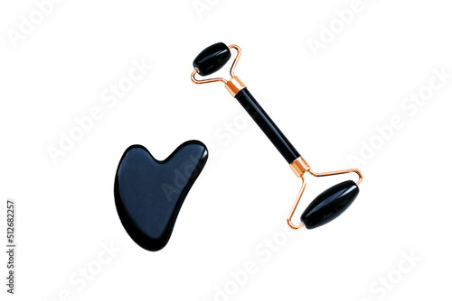 Black gua sha stone and roller for facial massage, horizontal photo on white background. Scraper for Chinese traditional massage, beauty procedure, skin care photo